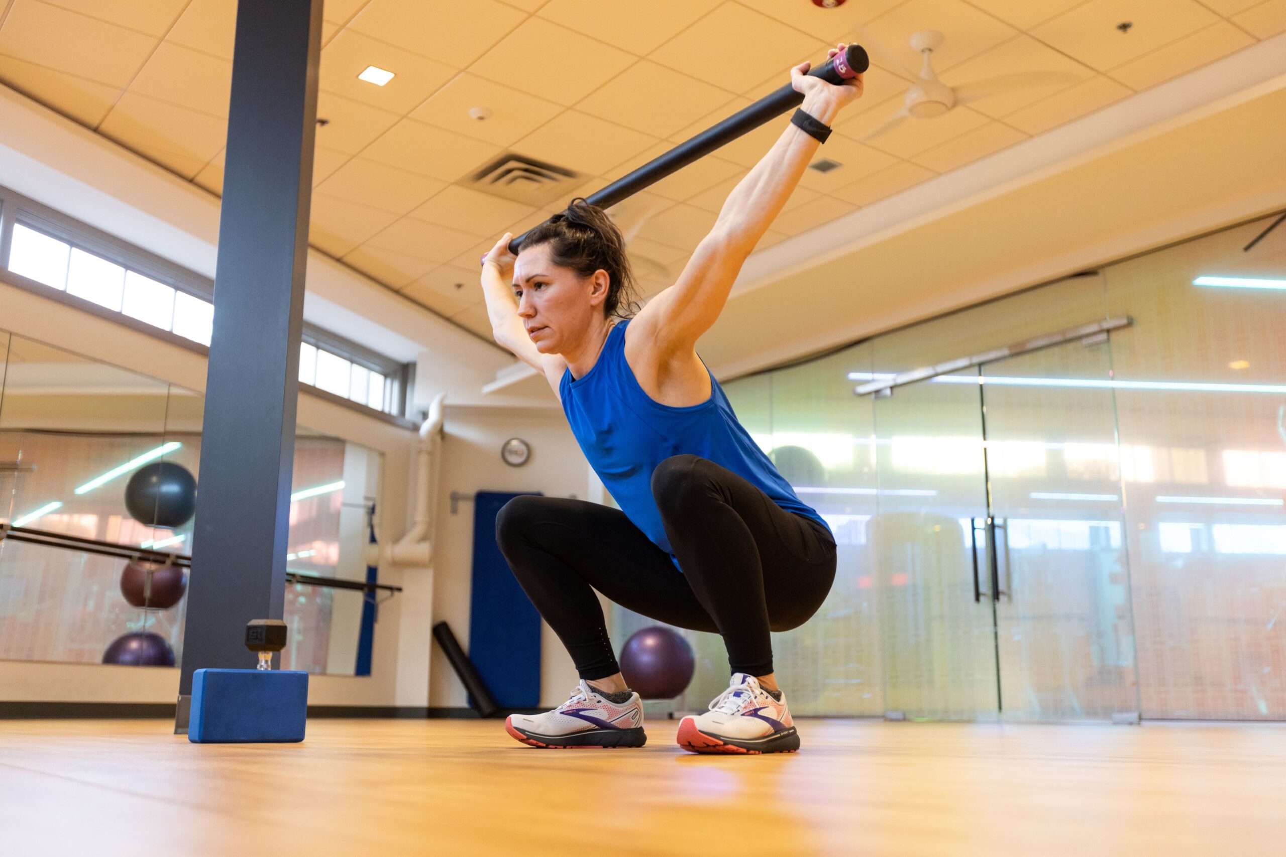 Personal trainer lifting a bar