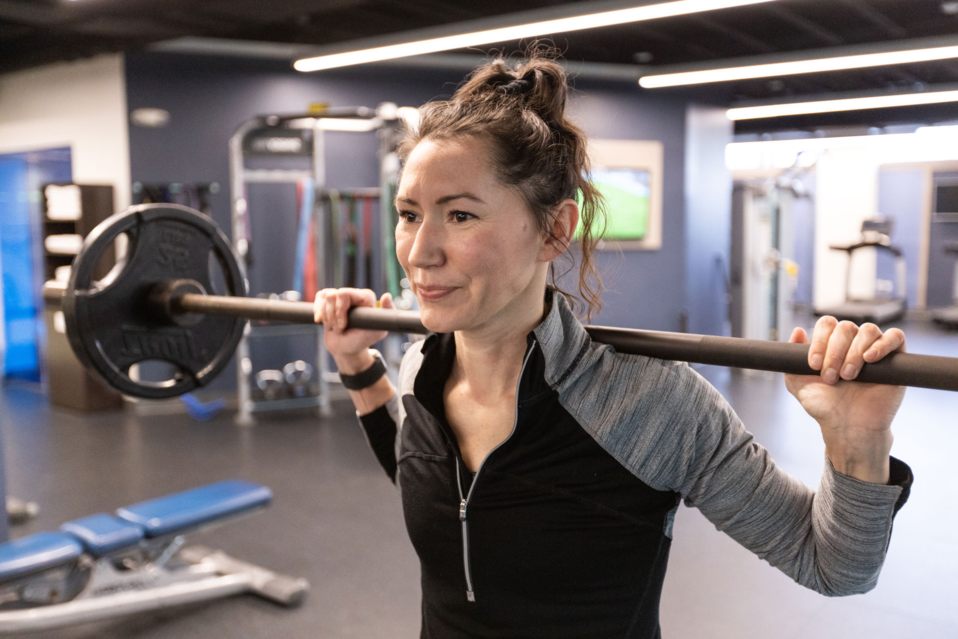 Personal trainer lifting weights above shoulders